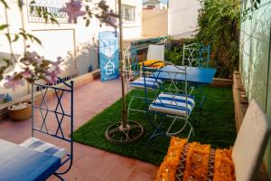 a patio with blue chairs on the grass at CoWork & Stay Suites in Agadir