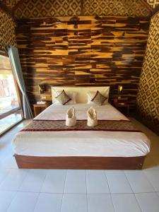 um quarto com uma cama com dois sapatos em Tebu menjangan homestay em Banyuwedang