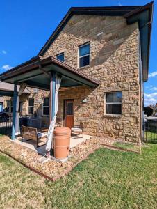 a stone house with an umbrella and a patio at Cozy Condo in Round Rock in Round Rock