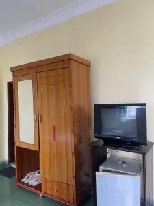 a wooden cabinet with a tv and a television at Hung Vuong Hotel in Pleiku