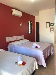 two beds in a room with red walls at Chalé recanto do sol in Santo Amaro +26 photos