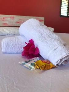 a towel on top of a bed with flowers on it at Chalé recanto do sol in Santo Amaro