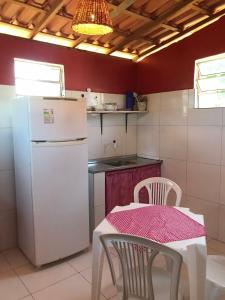 uma cozinha com um frigorífico branco e uma mesa com cadeiras em Chalé recanto do sol em Santo Amaro