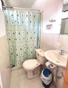 uma casa de banho com uma cortina de chuveiro, um WC e um lavatório. em Apartaestudio Centro Pereira em Pereira