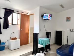 uma sala de estar com uma mesa e uma televisão na parede em Apartaestudio Centro Pereira em Pereira