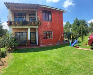 Cabaña “De Aurora” في مازاميتلا: منزل احمر وامامه ملعب