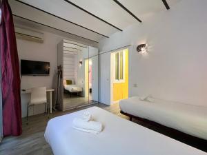 um quarto de hotel com duas camas e uma secretária em Stay U-nique Apartments Fontrodona em Barcelona