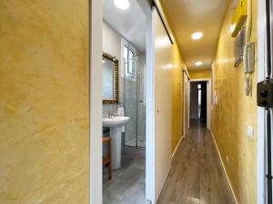 2 widoki na łazienkę z żółtymi ścianami i umywalką w obiekcie Stay U-nique Apartments Fontrodona w Barcelonie