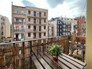 balcón con banco de madera y algunos edificios en Stay U-nique Apartments Fontrodona, en Barcelona