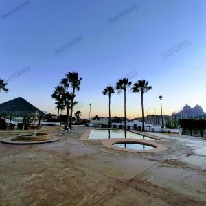 聖卡洛斯的住宿－Casa Villa Serena 5, enfrente de la alberca!，棕榈树停车场和喷泉