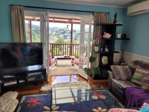 City Retreat في وانغاري: غرفة معيشة مع تلفزيون وشرفة