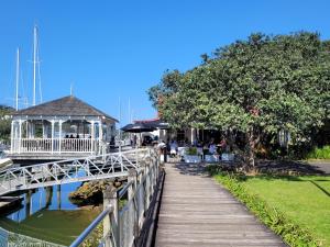 een promenade die leidt naar een restaurant naast een waterlichaam bij City Retreat in Whangarei