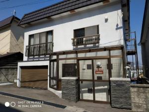 a large white building with a balcony on a street at Bay View House private room / Vacation STAY 3667 in Otaru