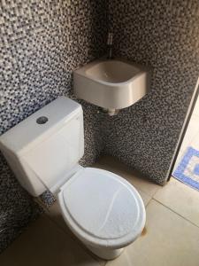ein Badezimmer mit einem weißen WC und einem Waschbecken in der Unterkunft Quarto Aconchego em Canaã dos Carajás in Canaã dos Carajás