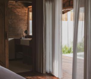 a bathroom with a sink and a mirror and a window at Kalyana Villa Gili Air in Gili Islands