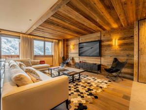 ein Wohnzimmer mit Couch und Flachbildfernseher in der Unterkunft Duplex Spacieux au Rond-Point des Pistes avec Parking, Balcon et Services Inclus - FR-1-613-93 in Les Allues