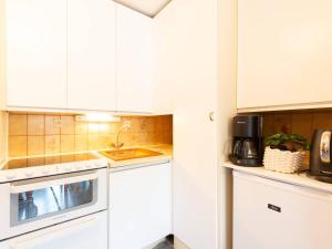 eine Küche mit weißen Schränken und einem Waschbecken in der Unterkunft Appartement Saint-Lary-Soulan, 2 pièces, 4 personnes - FR-1-296-479 in Saint-Lary-Soulan