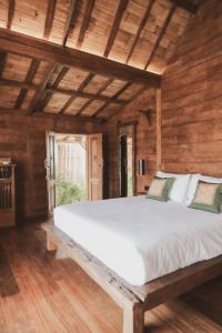 uma cama grande num quarto com paredes de madeira em Kalyana Villa Gili Air em Gili Air