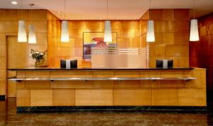 a lobby of a hotel with a wall of wood at NH Ciutat de Reus in Reus