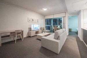 a living room with a couch and a tv at Comfy 2B1B CBD Riverview apt w Parking+Pool+Gym in Brisbane