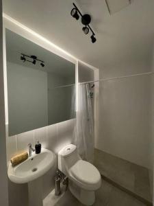 Baño blanco con aseo y lavamanos en Lovely 1 bedroom unit with free parking Modra zone 4 en Guatemala