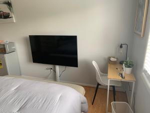 1 dormitorio con 1 cama y escritorio con TV en la pared en Little Paris Eiffel Tower Suite, en Owings Mills