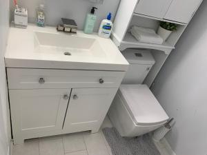 a bathroom with a white sink and a toilet at Little Paris Eiffel Tower Suite in Owings Mills