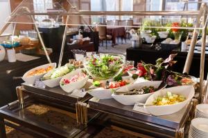 un buffet con tazones de verduras sobre una mesa en Kanazawa New Grand Hotel Prestige, en Kanazawa