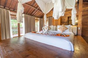 a bedroom with a large white bed in a room at Ayawana Private Villas Managed by ARM Hospitality in Tegalalang