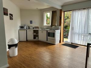 a kitchen with white appliances and a wooden floor at Owens Motel in Dunedin