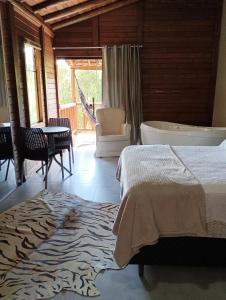 1 dormitorio con cama, bañera y mesa en Recanto Berço das Aguas en Piraquara