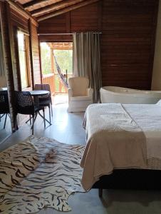 a bedroom with a bed and a bath tub and a table at Recanto Berço das Aguas in Piraquara +59 photos