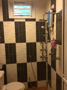 a bathroom with a shower with black and white tiles at Wan's Beach Guest House in Dungun