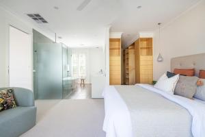 a bedroom with a large white bed and a couch at Hampton Haven Pool metres to the Beach in Melbourne