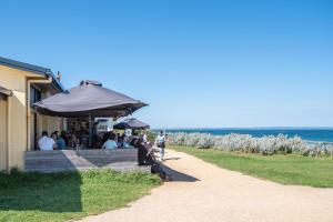 eine Gruppe von Menschen, die in einem Restaurant am Strand sitzen in der Unterkunft Beachside Vibes 2 min stroll to Parkdale Beach in Parkdale