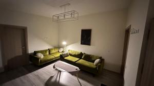 una sala de estar con 2 sofás verdes en una habitación en Aso Green ApartHotel Cluj Napoca en Cluj-Napoca