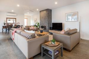 a living room with two couches and a fireplace at Somerset Sanctuary in Safety Beach in Safety Beach