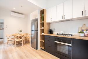 a kitchen with a stainless steel refrigerator and a table at Character and Charm on Emerald Hill in Melbourne
