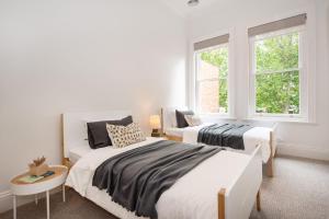 - 2 lits dans une chambre avec 2 fenêtres dans l'établissement Character and Charm on Emerald Hill, à Melbourne