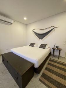 a bedroom with a large bed and a table at SABAI Beach in Barú