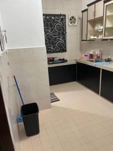 a kitchen with a refrigerator and a tile floor at SunShine HomeStay in Bukit Mertajam