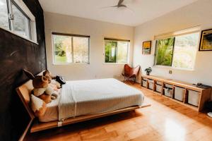 a bedroom with a bed with stuffed animals on it at Walk Minutes to beach/Ocean views/with AC/Waimea Bay in Haleiwa
