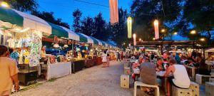 a group of people sitting at tables at an outdoor market at Huahin Myresort Family Suite Condo 3B2B Free water park มายรีสอร์ท หัวหิน 3 ห้องนอน 2 ห้องน้ำ พัก 8 คน ฟรีสวนน้ำ in Hua Hin