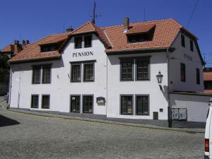 un edificio blanco con techo rojo en una calle en Pension U Soudu, en Český Krumlov