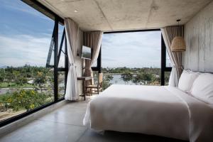 - une chambre avec un grand lit blanc et de grandes fenêtres dans l'établissement Thalia Boutique Hotel Hoian, à An Bàn (2)