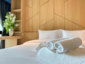 a pair of towels sitting on a bed at Hotel Fuse Rayong in Rayong
