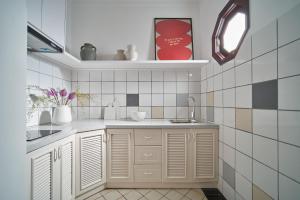 uma cozinha com armários brancos, um lavatório e um espelho em M Village CMT8 em Ho Chi Minh