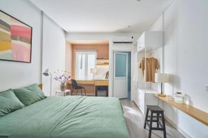 een slaapkamer met een groen bed en een bureau bij M Village CMT8 in Ho Chi Minh-stad