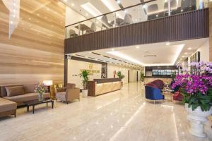 a lobby with couches and tables and flowers at Western Skyline Hotel HN - by BAY LUXURY in Hanoi