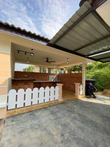 a patio with white chairs under a roof at AA SWEET ROOM TANJUNG BIDARA MELAKA in Masjid Tanah